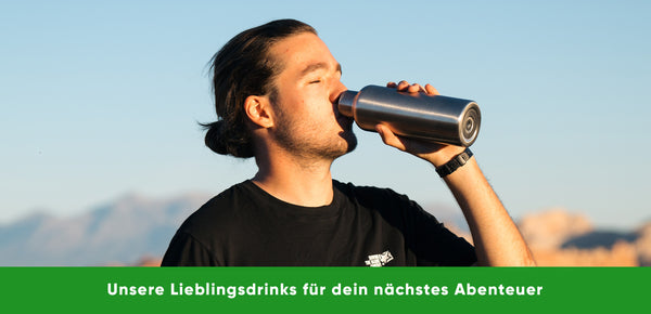 Ein Mann mit schwarzem T-Shirt trinkt aus der Blockhütte Edelstahl Trinkflasche