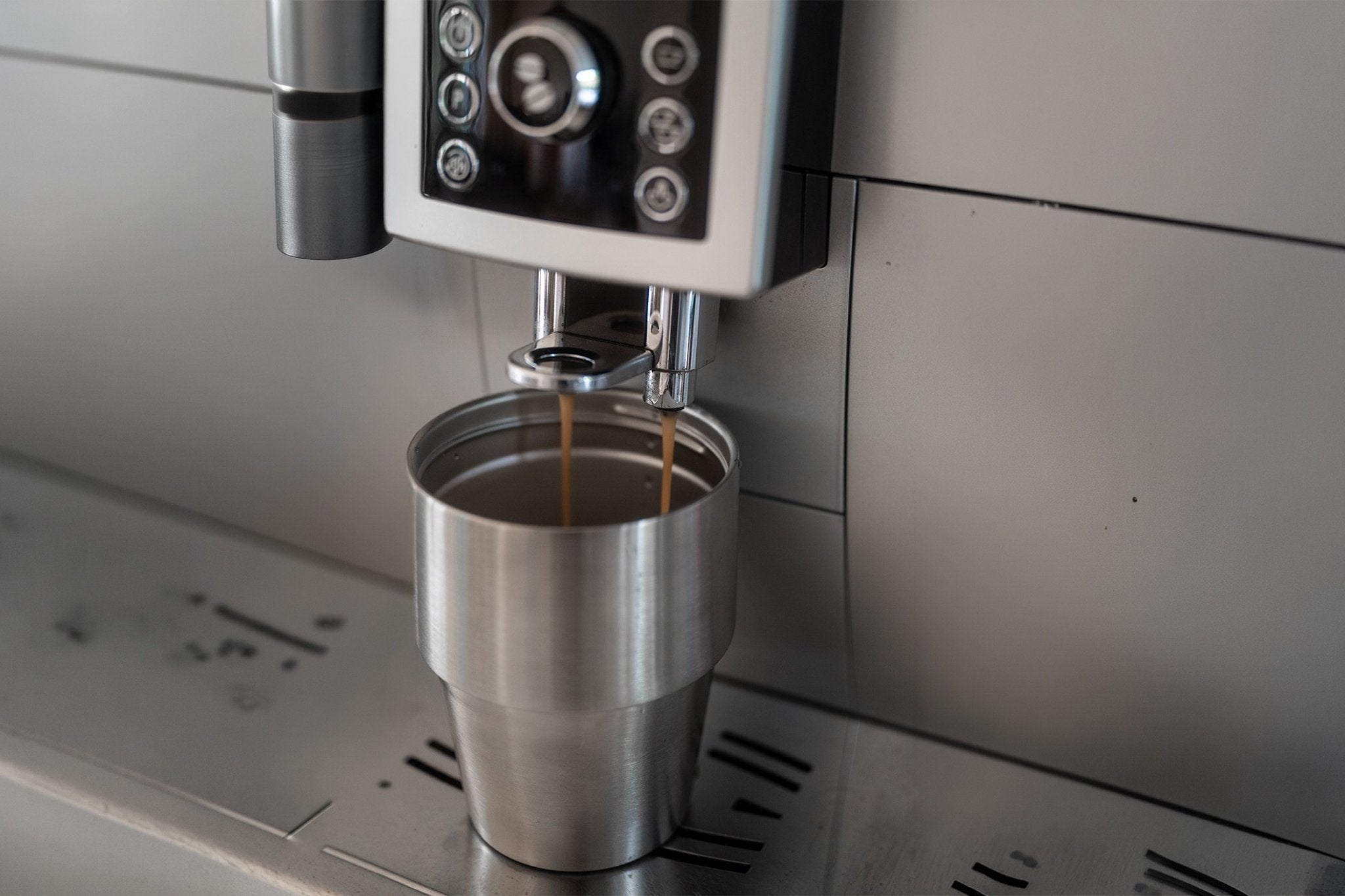Kaffee läuft aus dem Vollautomaten direkt in den Edelstahl-Thermobecher